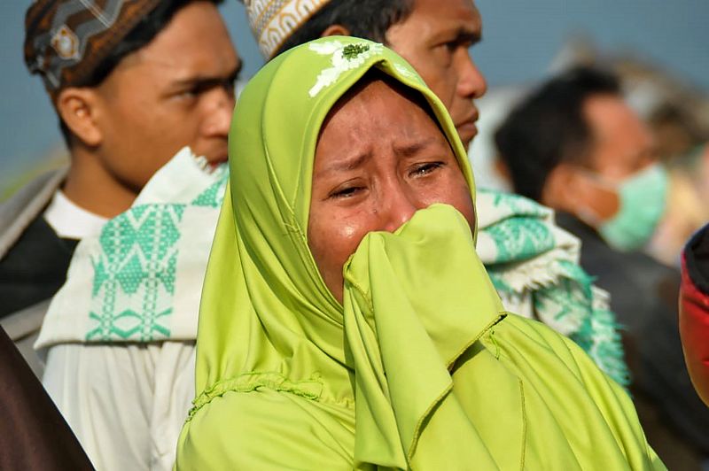 Una mujer llora mientras mira el daño provocado por el terremoto-tsunami en Palu