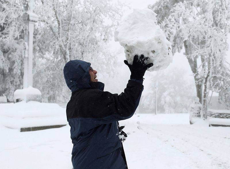 Un persona sostiene una gran bola de nieve en O Cebreiro, Lugo