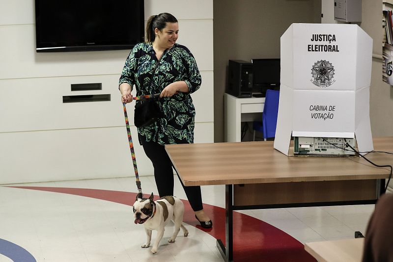 Una mujer con su perro tras votar en un colegio electoral en Sao Paulo