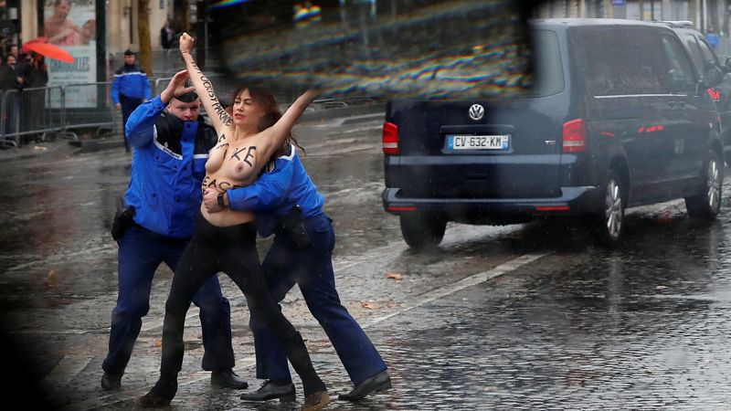 Una activista de Femen salta el cordón policial y protesta frente a la caravana de Donald Trump en París, durante los actos de conmemoración del centenario del armisticio de la Primera Guerra Mundial. REUTERS/Carlos Barria