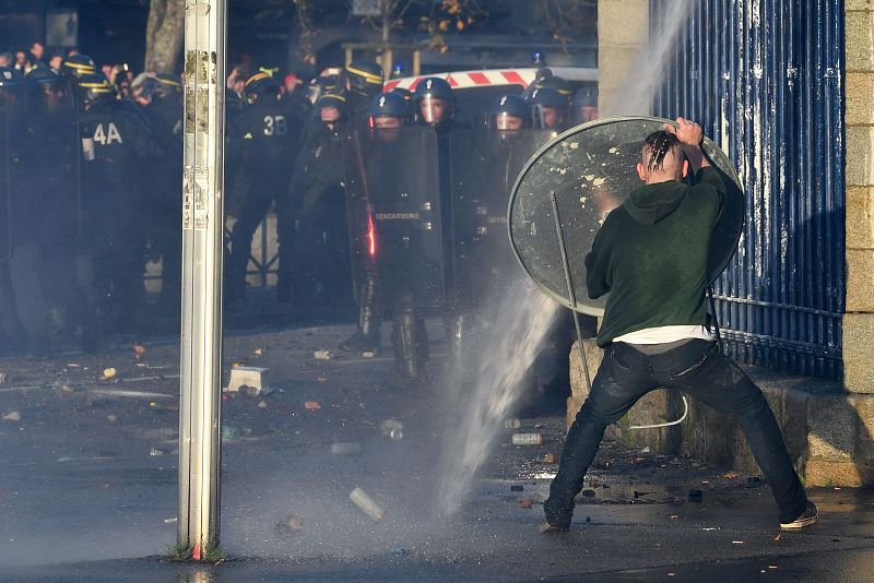 Un hombre se protege de la policía con una señal de tráfico en Quimper