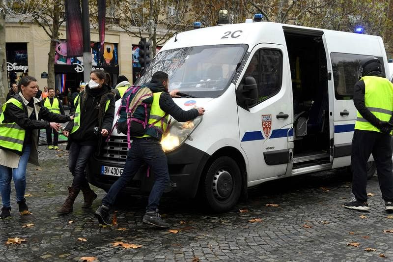 Un grupo de "chalecos amarillos" rodea una furgoneta de la policía