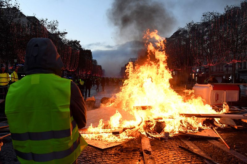 Los "chalecos amarillos" permanecen detrás de una barricada en llamas en los Campos Elíseos