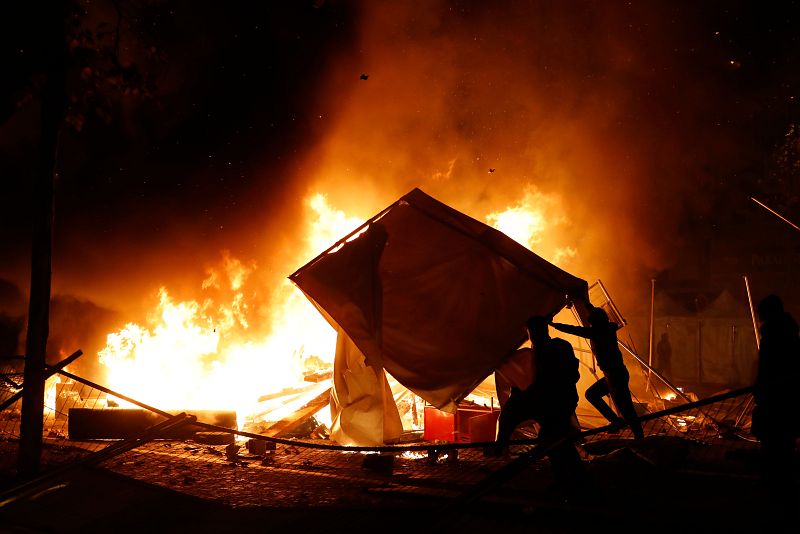 Un manifestante arroja material para avivar una hoguera en los Campos Elíseos