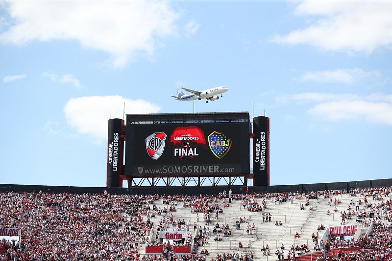 Un avión pasa sobre la pantalla del estadio Monumental hoy antes del partido de la final de la Copa Libertadores entre River Plate y Boca Juniors en Buenos Aires (Argentina).