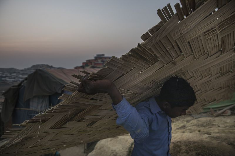 Un niño acarrea una pared de bambú en el asentamiento de Jamtoli