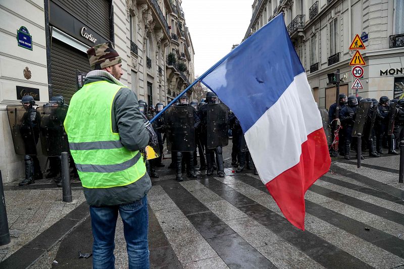 Un manifestante ondea una bandera de Francia frente a la Policía
