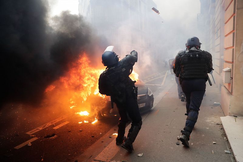 Un policía antidisturbios arroja gas lacrimógeno