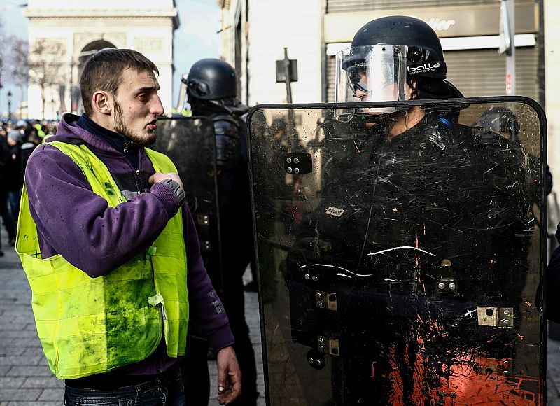 Un manifestante habla con un policía cerca de los Campos Elíseos