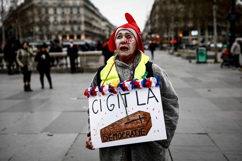 Un manifestante con una pancarta en la que se lee "Aquí yace la democracia"