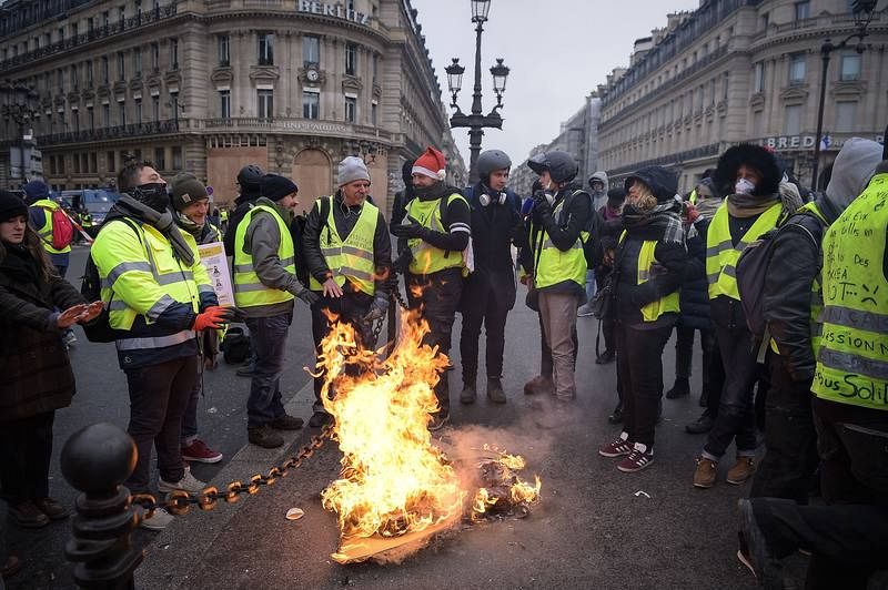 Un grupo de manifestantes se calienta las manos en una fogata