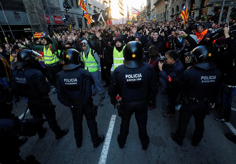 Un millar de manifestantes permanecen concentrados frente a un cordón policial que les impide el paso en la avenida Paral·lel de Barcelona, en la confluencia con el portal de Santa Madrona, blindada con numerosos antidisturbios equipados con cascos y