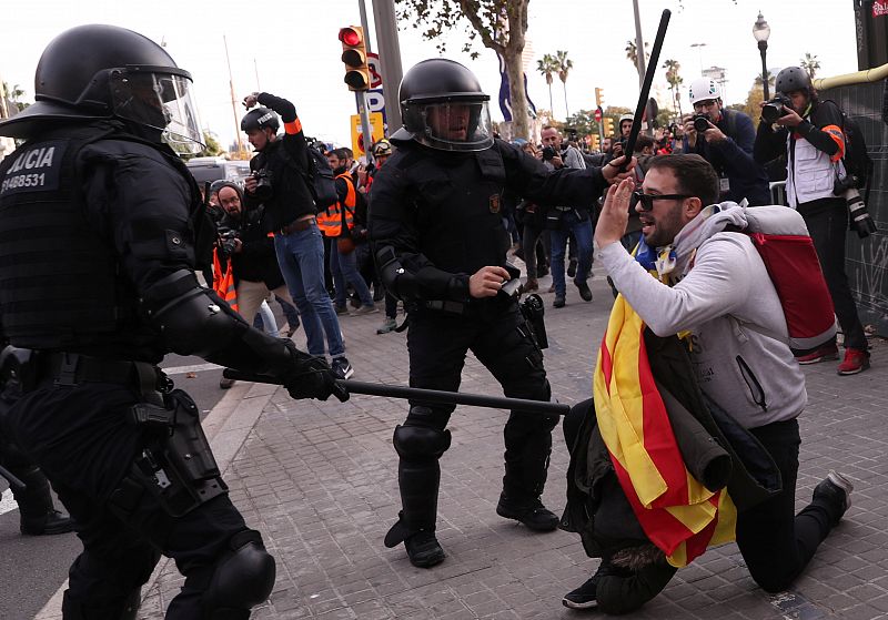 Un policía detiene a un manifestante en la protesta por la celebración del Consejo de Ministros en Barcelona