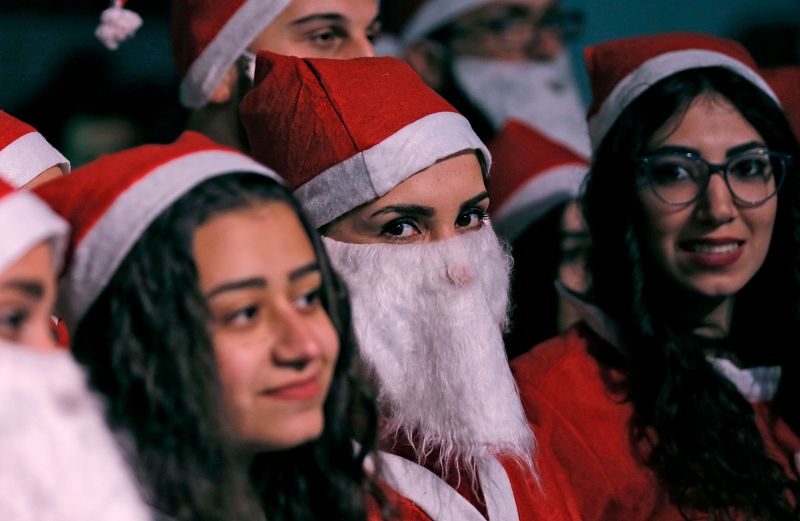 Jóvenes sirias vestidas de Papá Noel celebran la Navidad en el barrio de Qassaa, en Damasco.