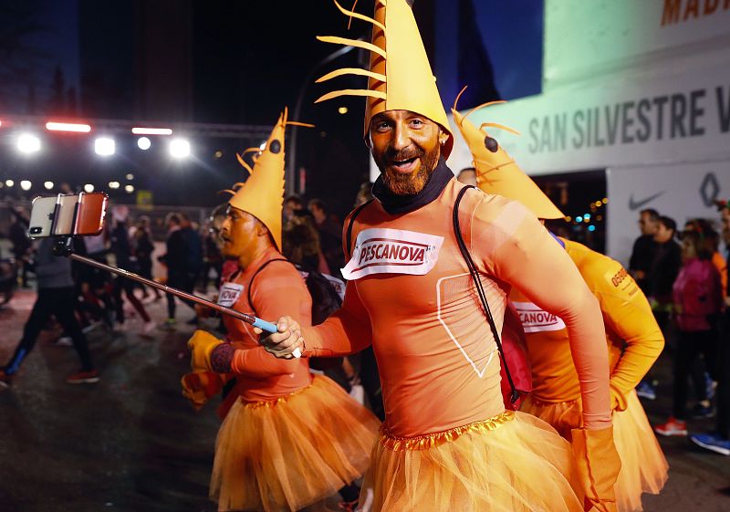Corredores disfrazados tras tomar la salida de la San Silvestre Vallecana Popular, la emblemática carrera del final del año en Madrid.