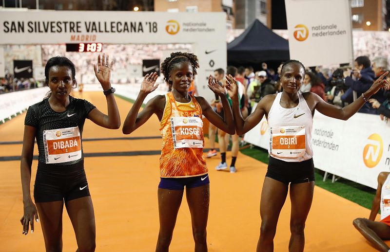 La keniana Brigid Kosgei (c), vencedora de la San Silvestre Vallecana, junto a la segunda, la etíope Tirunesh Dibaba (i), y la tercera, la keniana Hellen Obiri (d), en la meta.