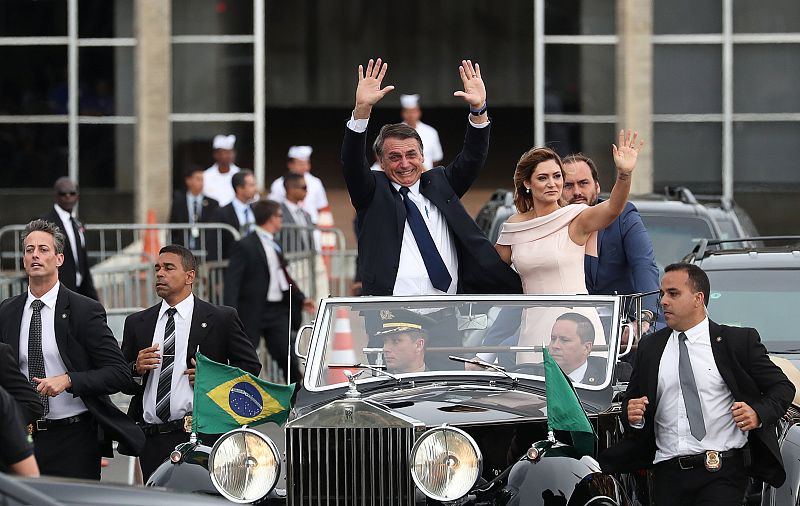 El nuevo presidente de Brasil, Jair Bolsonaro, y su esposa Michelle saludan a la multitud mientras se dirigen a la ceremonia de toma de posesión del cargo