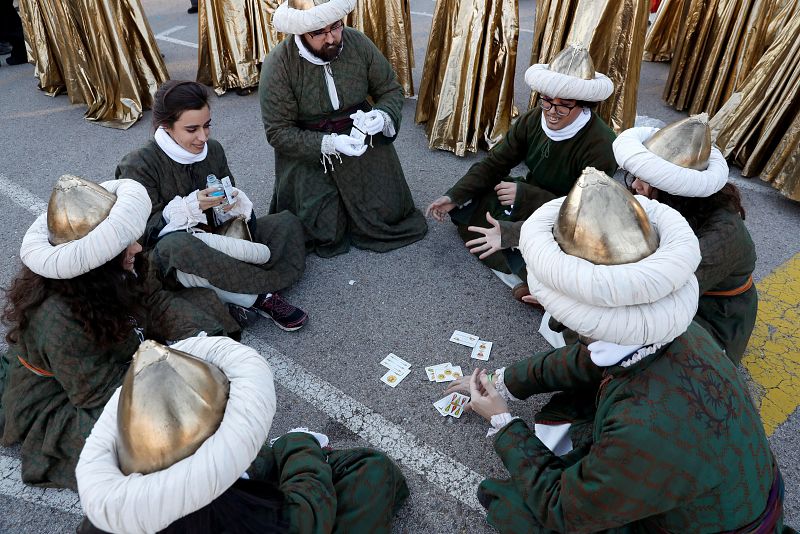 Varios participantes en la cabalgata de Madrid se distraen jugando a las cartas