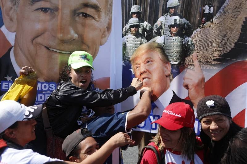 Simpatizantes del presidente Nicolás Maduro golpean una pancarta con una foto del presidente de Estados Unidos, Donald Trump, en Caracas