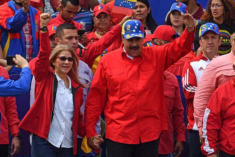 El presidente de Venezuela, Nicolás Maduro, saluda junto a su esposa Cilia Flores durante la marcha convocada para celebrar el 20 aniversario de la subida al poder de Hugo Chávez