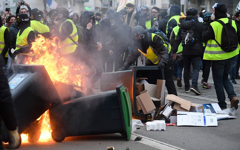 Un grupo de manifestantes incendia unos contenedores de basura en Lorient