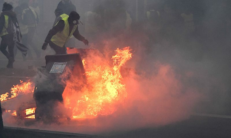 Una barricada arde mientras los manifestantes se enfrentan a los antidisturbios