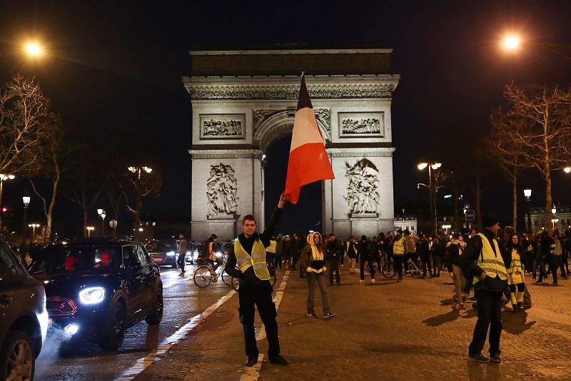 Un manifestante ondea la bandera de Francia en los Campos Elíseos en París