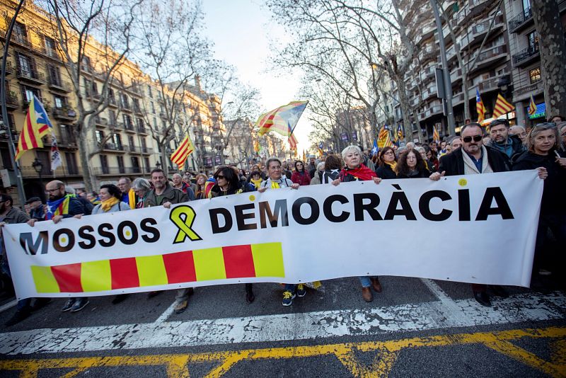 Un grupo de manifestantes con una pancarta en la que se lee "Mossos y Democracia"