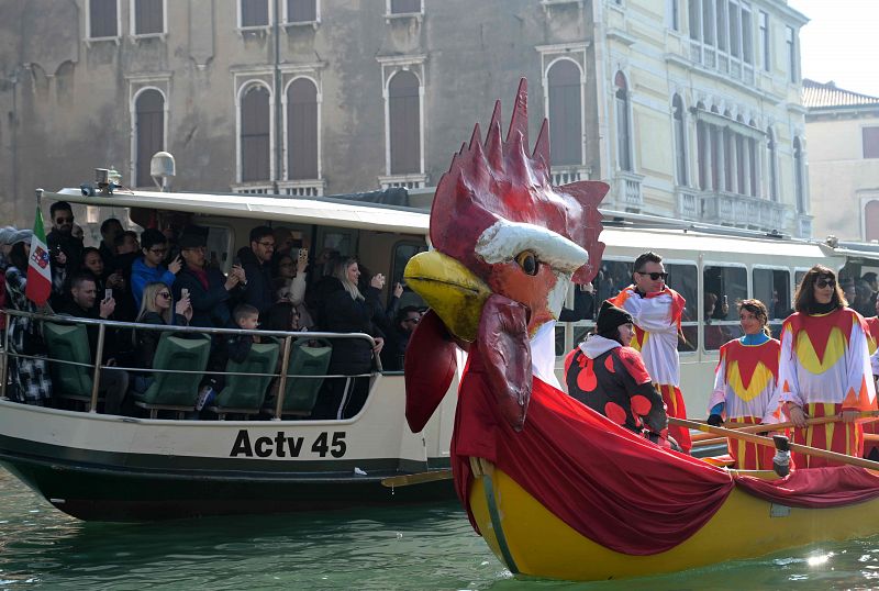 Los turistas hacen fotos a una barca desde un Vaporetto