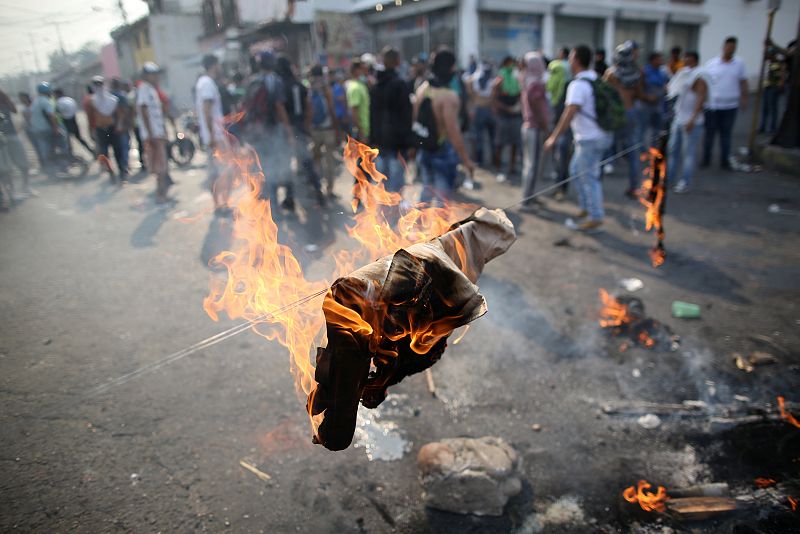 Unos manifestantes queman la ropa de la milicia en el municipio de Ureña, Venezuela.