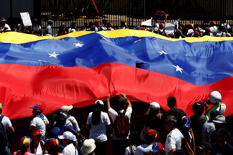 Los partidarios del líder opositor venezolano, Juan Guaidó, sostienen una bandera gigante durante las protestas en Caracas.