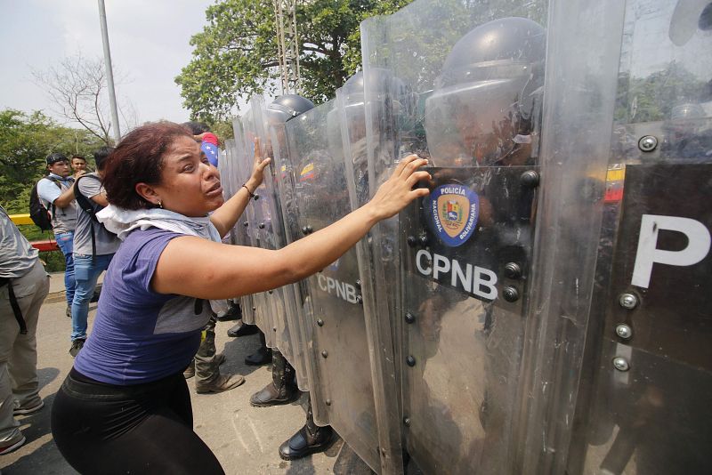 Una mujer frente a las fuerzas de seguridad del Gobierno de Maduro en el puente de Simón Bolivar