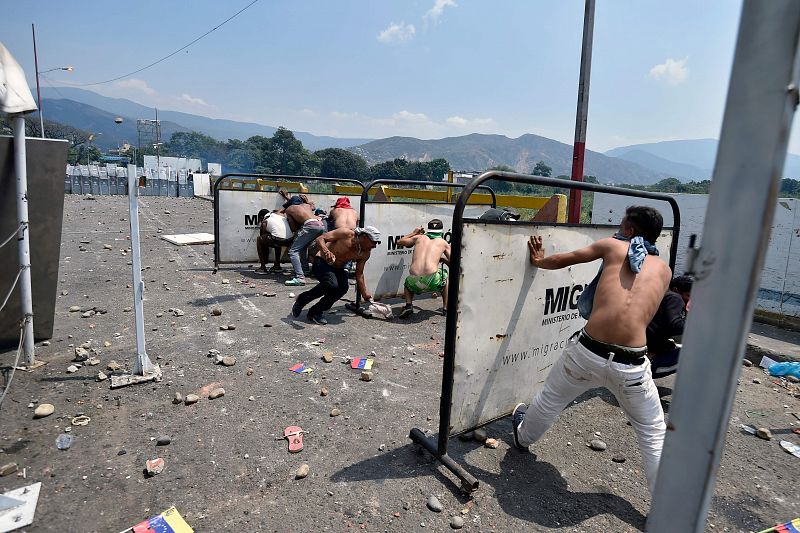 Policías nacionales venezolanos se enfrentan a manifestantes en el puente internacional Simón Bolívar, en el paso fronterizo en Cúcuta