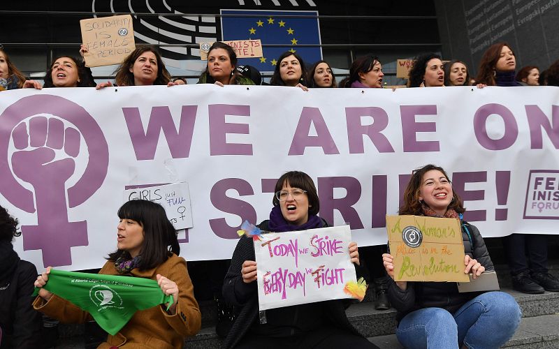 Las mujeres miembros del Parlamento Europeo sostienen una pancarta que dice "Estamos en huelga" mientras protestan en la entrada principal del Parlamento Europeo para conmemorar el Día Internacional de la Mujer en Bruselas.