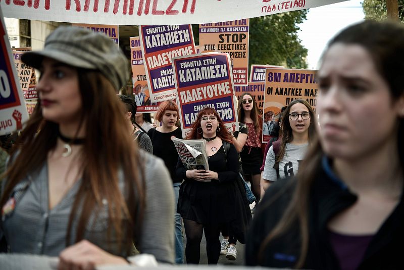 Un grupo de mujeres jóvenes gritan consignas feministas mientras participan en una marcha en el centro de Atenas.