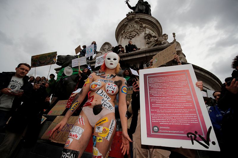 Una mujer enmascarada y con el torso desnudo protesta por el uso de los cuerpos de las mujeres en la publicidad durante la protesta en la Plaza de la República de Paris.