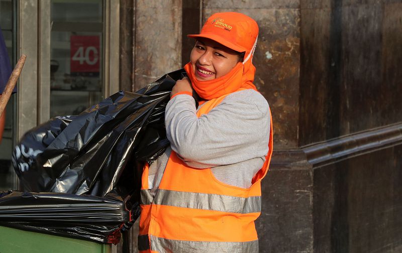 Una trabajadora de limpieza sonríe mientras desempeña sus labores este viernes, en Lima (Perú).