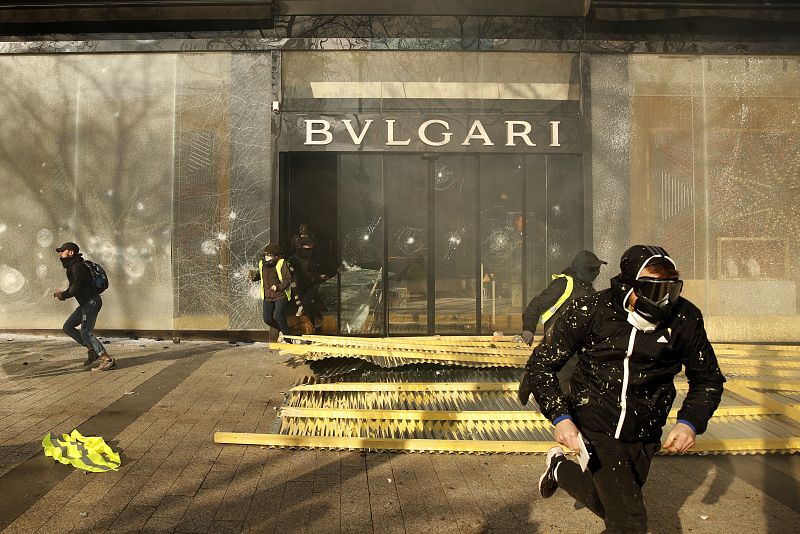 Un grupo de personas destroza el escaparate de la tienda de Bulgari en los Campos Elíseos