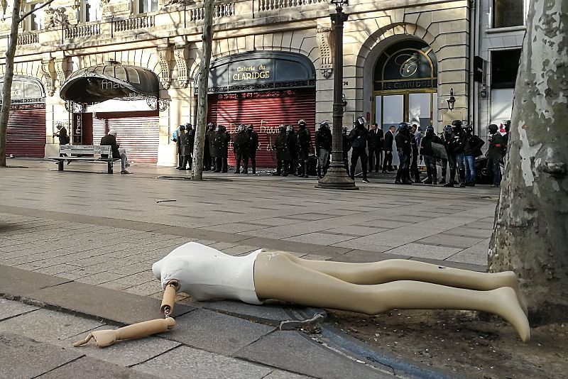 Policías antidisturbios protegen la entrada a una galería comercial en los Campos Elíseos