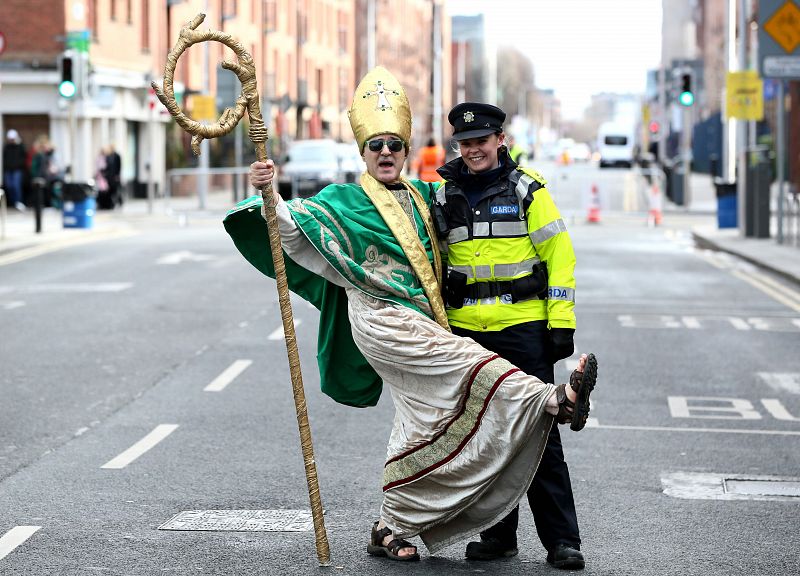 Un hombre disfrazado de San Patricio posa con una oficial de policía en Dublín, Irlanda