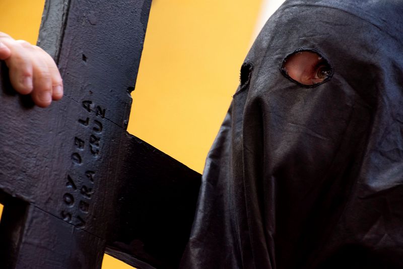 Un nazareno de la Hermandad de La Vera Cruz, durante su estación de penitencia en la tarde del Lunes Santo en Sevilla. 