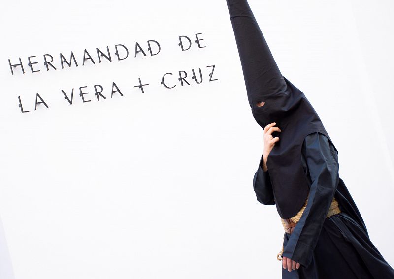  Un nazareno de la hermandad de la Vera Cruz, se dirige a su templo para iniciar su estación de penitencia, este Lunes Santo en Sevilla. 