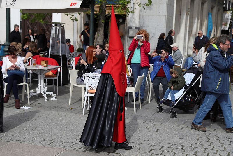 Un nazareno acompaña al paso del Santísimo Cristo Yacente, en la procesión de Sábado Santo en Madrid