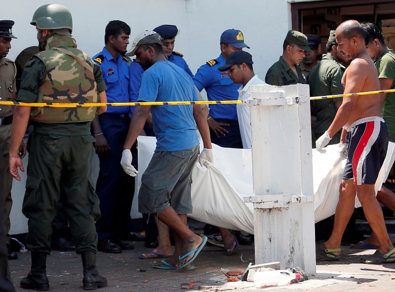 Un grupo de personas lleva un cadáver a una ambulancia cerca del Santuario de San Antonio de Colombo