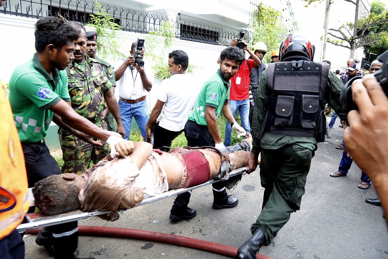 Personal de seguridad evacúa a uno de los heridos en la explosión del área de Dematagoda, Colombo