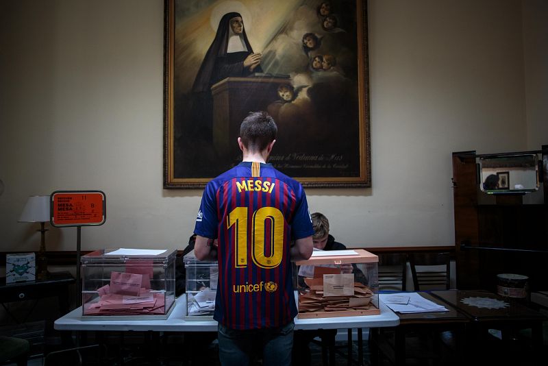 Una persona ejerce su derecho al voto para las elecciones generales y autonómicas en Valencia vestido con la camiseta de Messi del F.C. Barcelona, que este sábado ganó el título de Liga en el Camp Nou