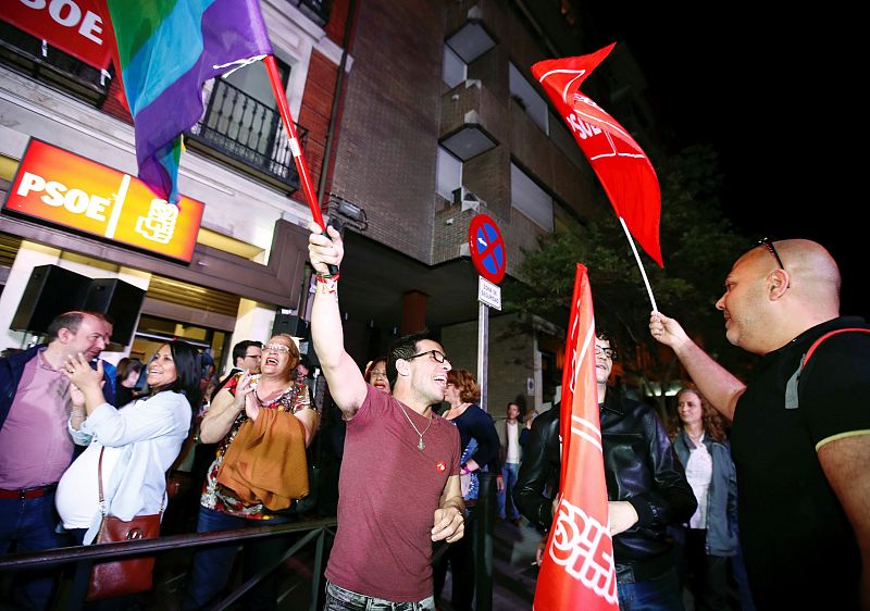 Personas congregadas a las puertas de la sede del PSOE en Madrid desde donde siguen el escrutinio de las elecciones