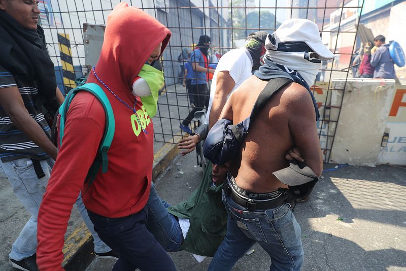 Simpatizantes de Guaidó ayudan a un herido durante una manifestación en apoyo a su levantamiento contra el gobierno de Nicolás Maduro este martes.