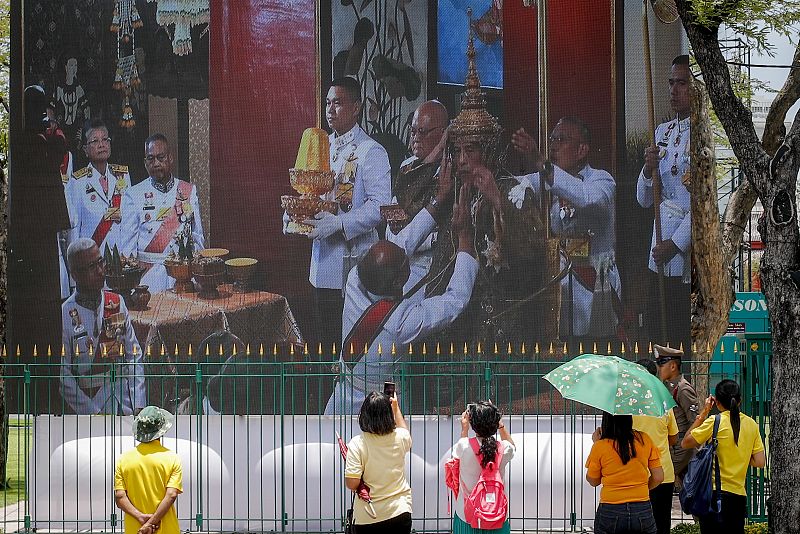 La población tailandesa sigue la ceremonia de coronación del Rey Maha Vajiralongkorn Bodindradebayavarangkun a través de una pantalla gigante situada fuera del Gran Palacio de Bangkok.