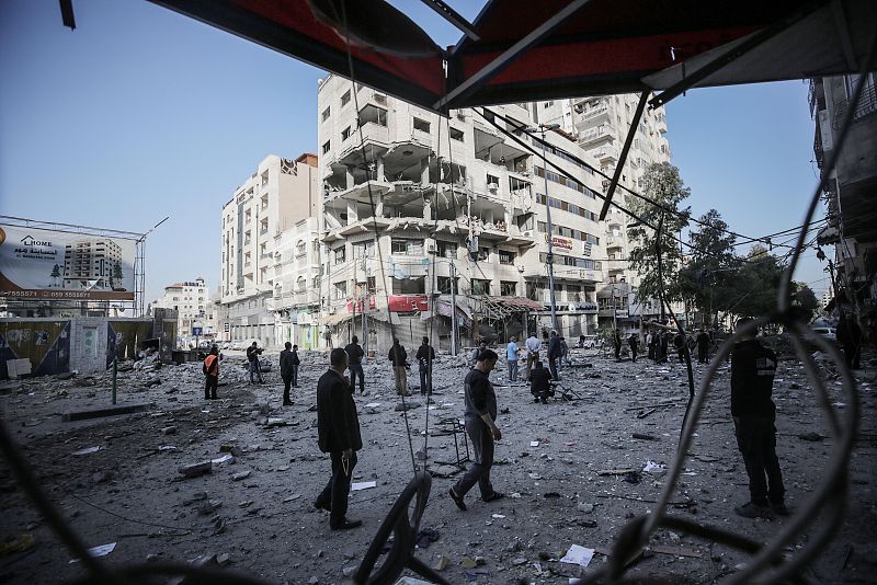Varias personas inspeccionan un edificio dañado en Gaza tras un ataque aéreo israelí